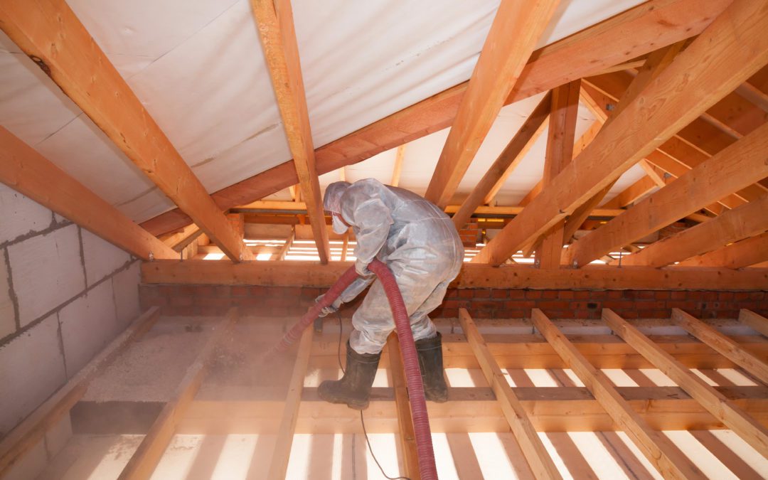 worker installing attic insulation